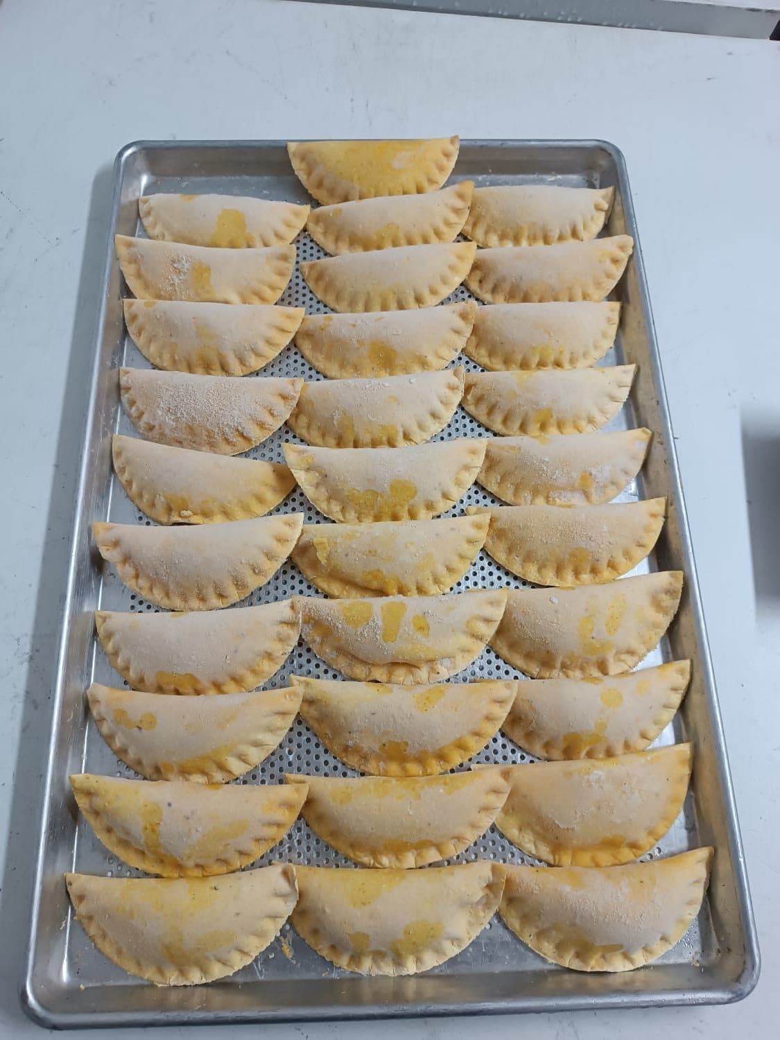 Bandeja de empanadas Croky crudas antes de congelarlas